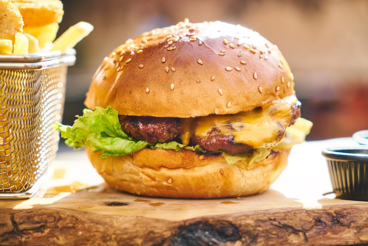 services-05 Juicy cheeseburger with crispy fries served on a wooden board, perfect fast food delight.