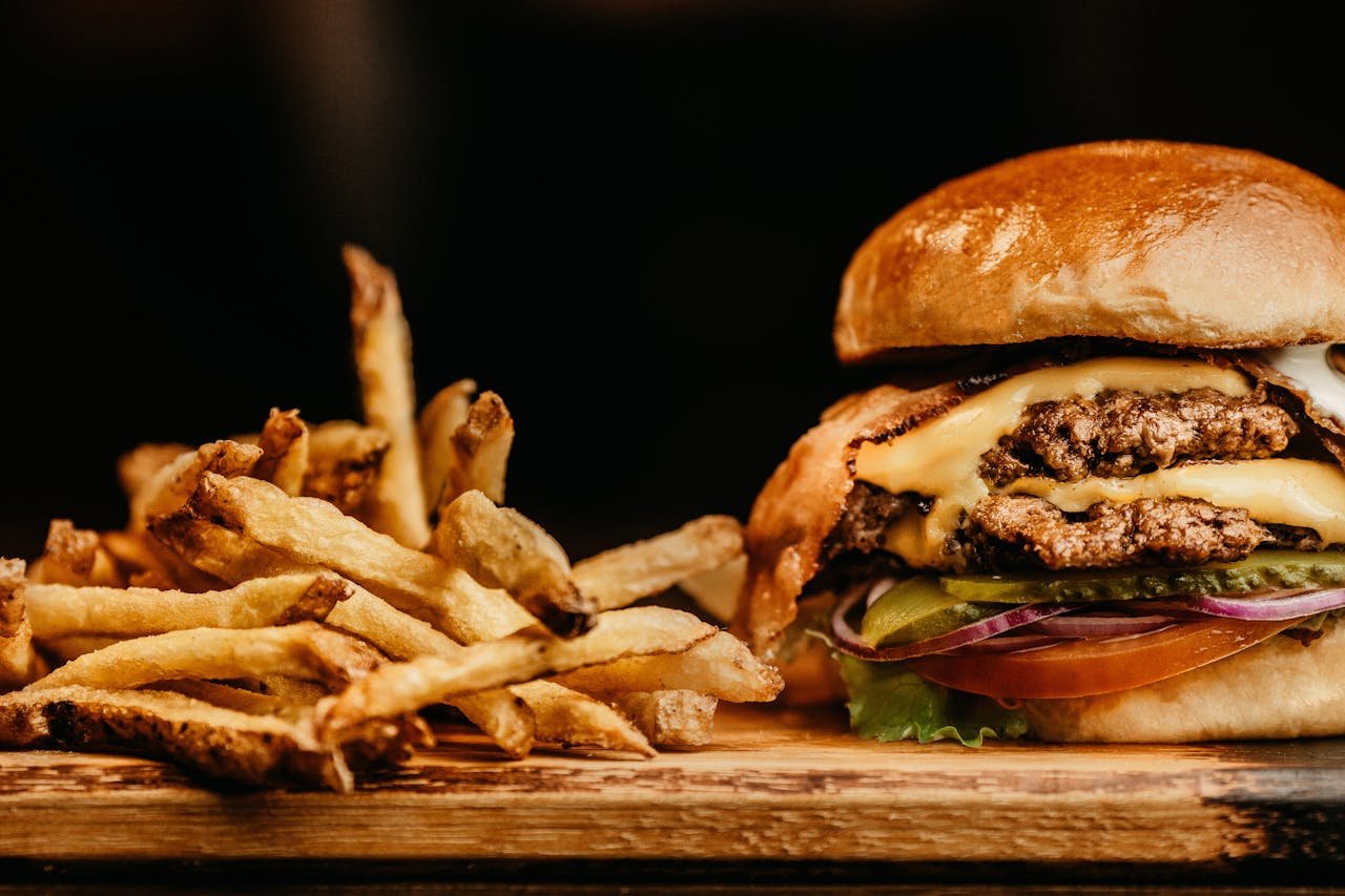 services-06 Mouthwatering cheeseburger and crispy fries on a wooden board, perfectly capturing fast food appeal.