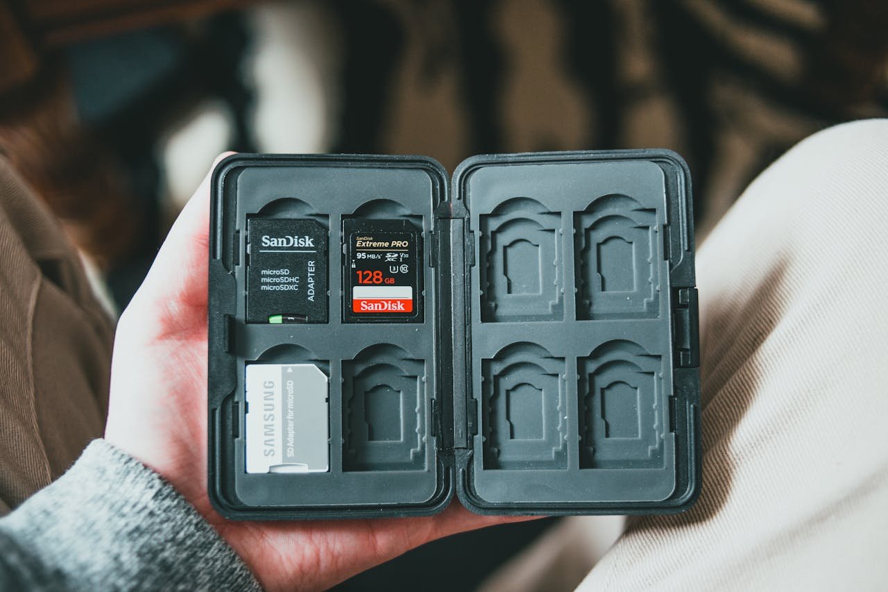 A memory card holder with various SD cards inside, held in a person's hand.